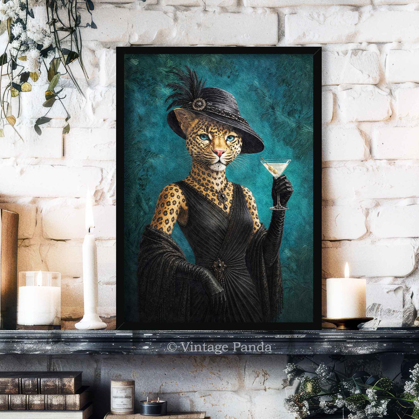 A framed art print featuring a leopard dressed in a black vintage gown and hat, holding a martini glass, displayed on a dark mantelpiece against a white brick wall with candles and books.